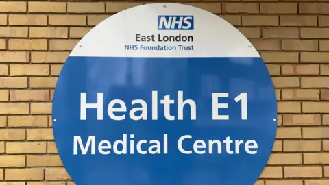 Getty Images The front of a homeless medical centre run by East London NHS Foundation Trust in London. The picture shows a sign that says Health E1 Medical Centre with a brick wall behind it